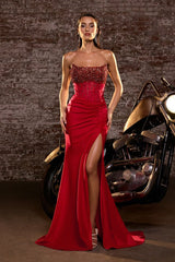 Model wearing a strapless gown featuring a beaded corset bodice, ruched waist detailing, and high side slit