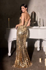 Woman in a gold sequin dress standing in front of a white piano with candles.