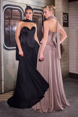 Two women in evening gowns standing in a subway station.
