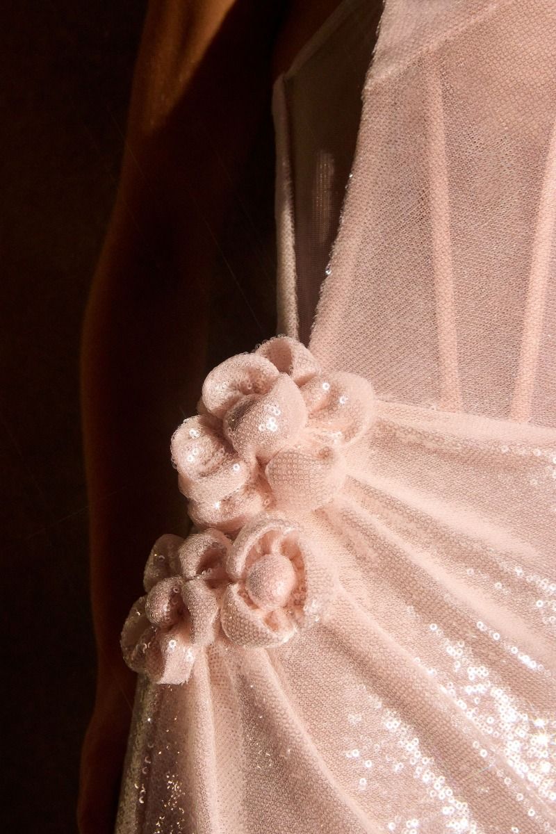 fitted gown stuns with its sleek strapless neckline and gleaming sequin finish