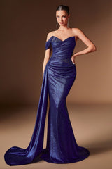 A woman models a floor-length, off-the-shoulder evening gown in a rich royal blue sequined fabric with a sweetheart neckline and a dramatic train, set against a solid warm brown studio background.
