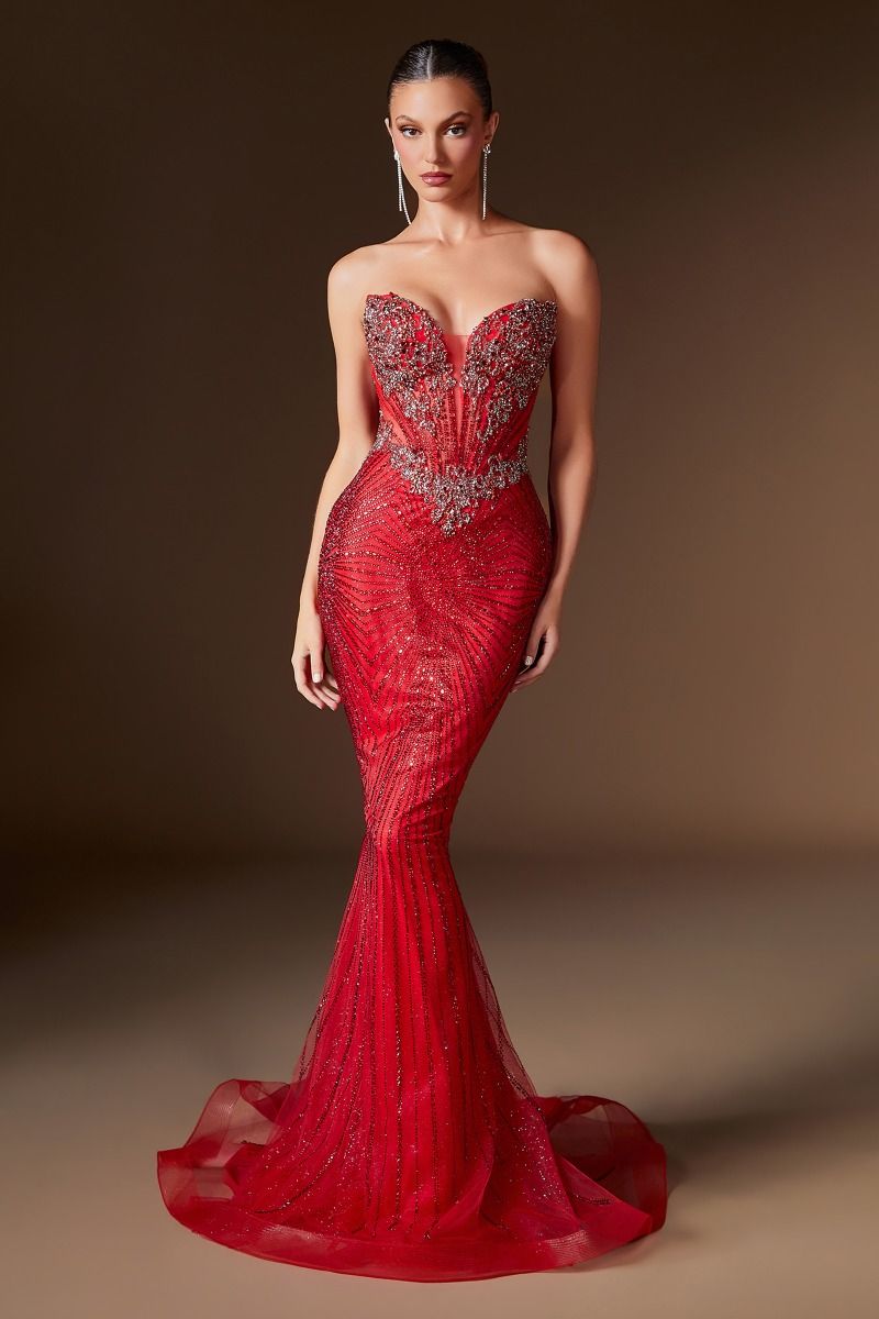 Woman wearing a red evening gown with intricate detailing on a brown background