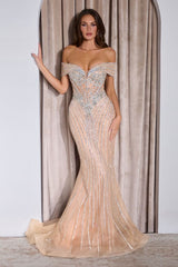 Woman wearing a glamorous evening gown with intricate detailing in front of a neutral curtain.