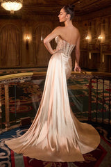 dress features an embellished, corset-style bodice with intricate silver detailing and a softly draped skirt that flows into a long train.