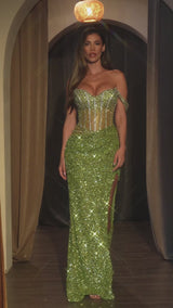 fitted gown features an off-the-shoulder sweetheart neckline and a sheer bodice adorned with shimmering sequins and bead embellishments. 