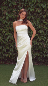 fitted strapless gown, crafted from luxe satin, features a sleek straight neckline, gathered waistline, and elegant leg slit