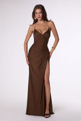 Woman wearing a brown evening gown with a high slit on a white background
