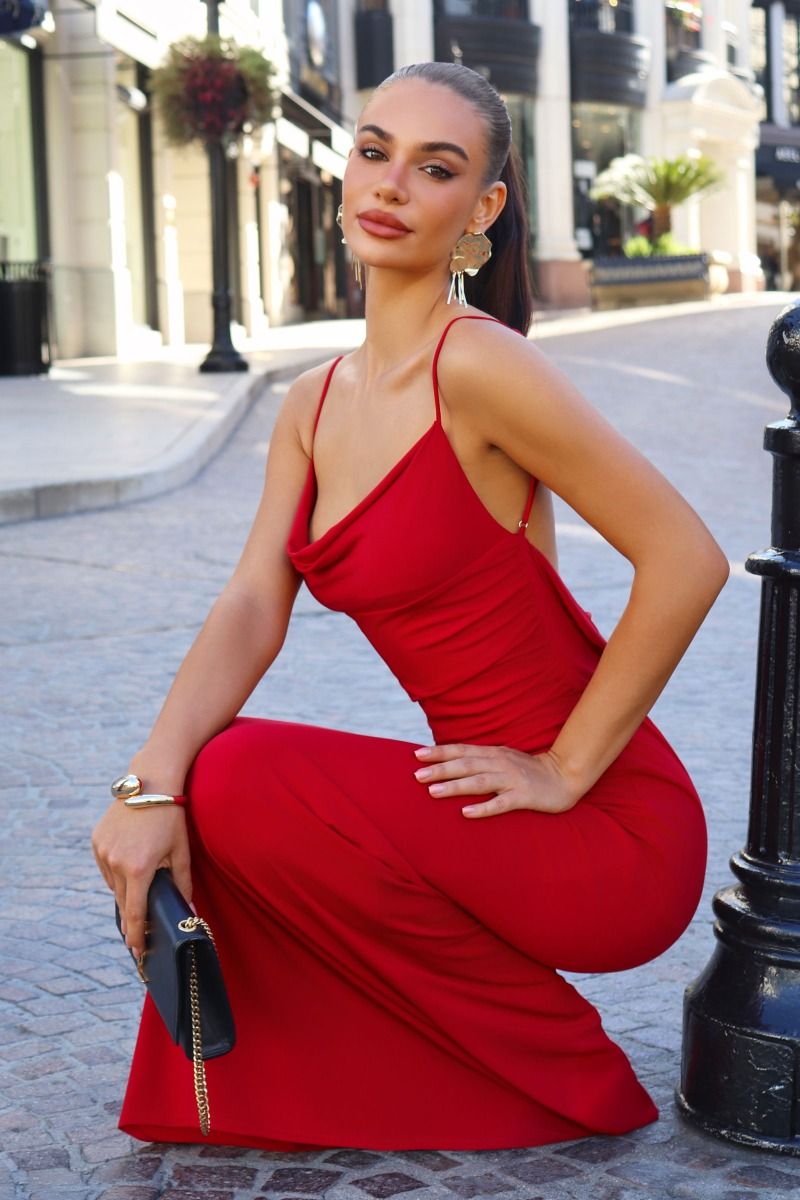 Woman in a red dress posing on a city street.