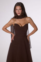 Woman wearing a brown dress with a plain background