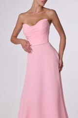 Pink strapless gown on a plain background