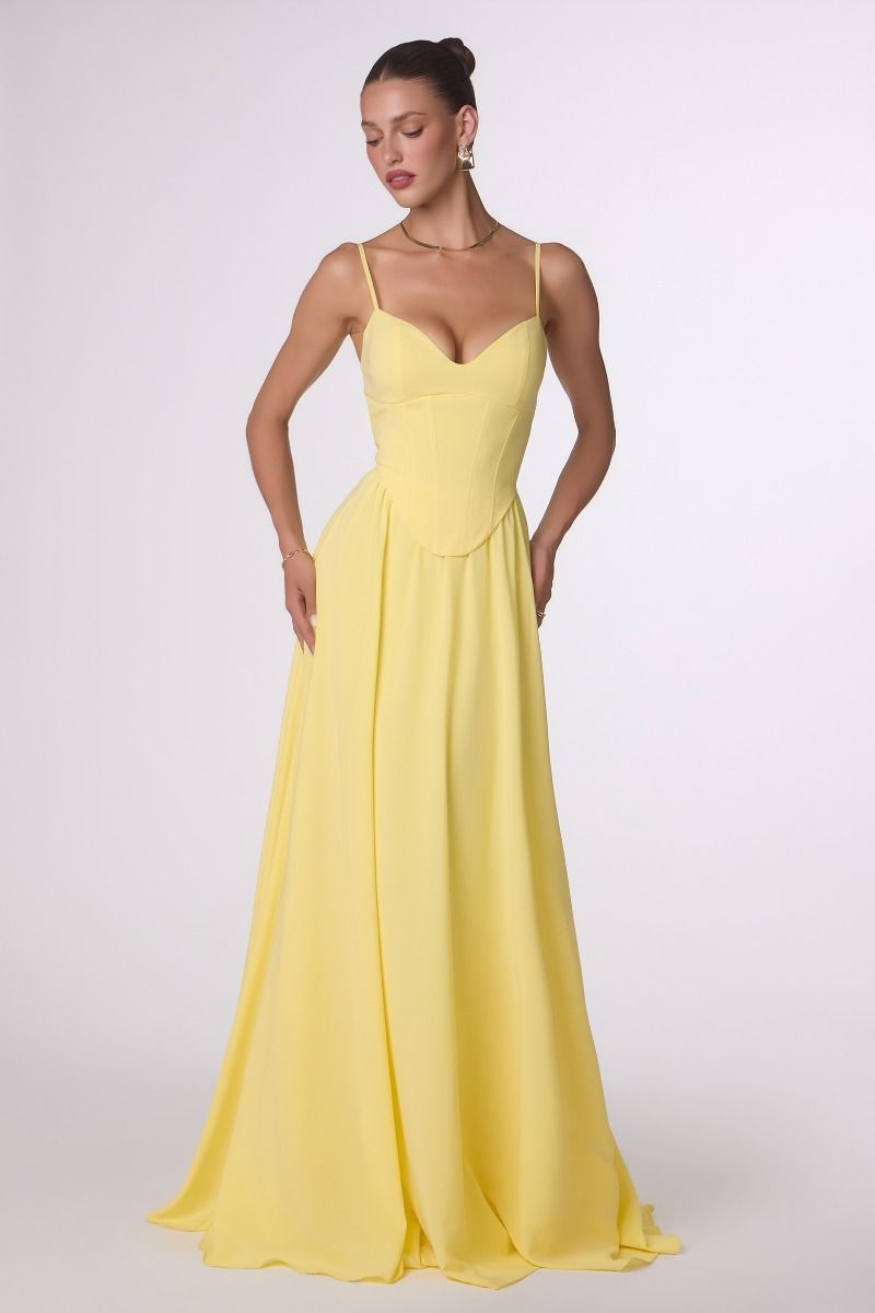 Woman wearing a yellow evening gown on a white background