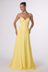 Woman wearing a yellow evening gown on a white background