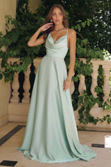 Model wearing a satin gown with draped cowl neckline, fitted waist, and floor-length skirt, featuring thin crisscross straps and open back