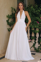 Model wearing a halter maxi dress featuring a plunging neckline, ruched waist, and flowing floor-length skirt