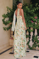 Woman in a floral dress standing in front of greenery