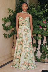Woman in a floral dress standing in front of greenery