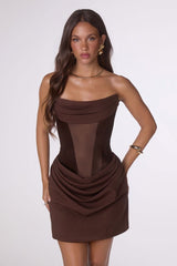 Woman wearing a brown strapless dress on a white background