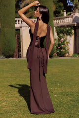 Woman in a brown evening gown standing on grass with a garden background