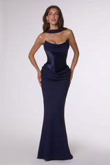 Woman wearing a navy strapless gown on a white background