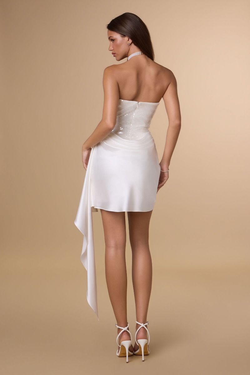 Woman wearing a white dress with a beige background