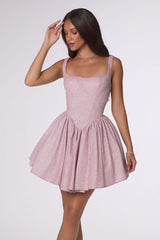 Woman wearing a pink dress against a white background