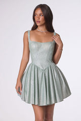 Woman wearing a light green dress against a white background