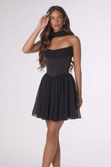 Woman wearing a black dress against a white background