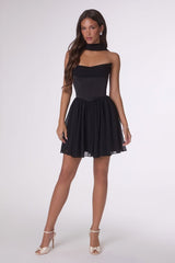 Woman wearing a black strapless dress on a white background