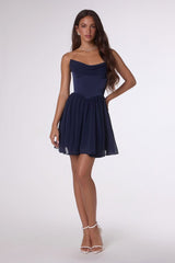 Woman wearing a navy strapless dress on a white background