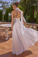 Woman in a white dress standing outdoors on a sunny day.