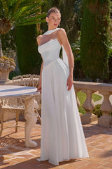 Woman in a white strapless gown standing outdoors with greenery in the background