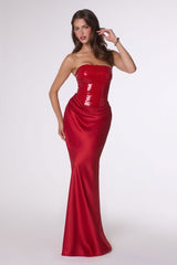 Woman wearing a red strapless gown on a white background