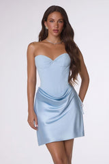 Woman wearing a light blue strapless dress on a white background