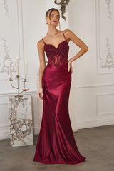 Woman wearing a burgundy evening gown in an elegant room.