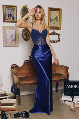 Woman in a blue evening gown standing in a room with vintage decor.
