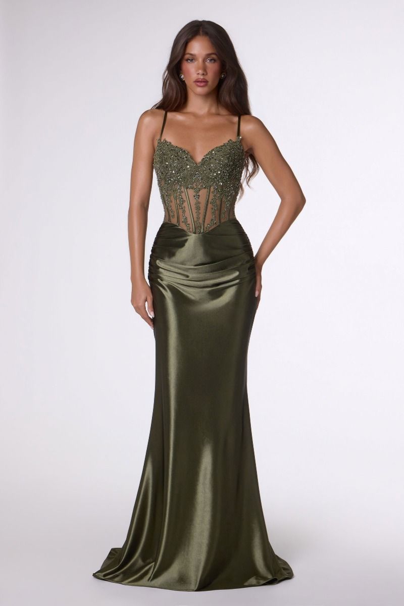 Woman wearing a green evening gown with a beaded bodice on a white background