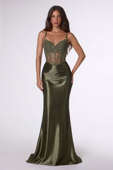 Woman wearing a green evening gown with a beaded bodice on a white background