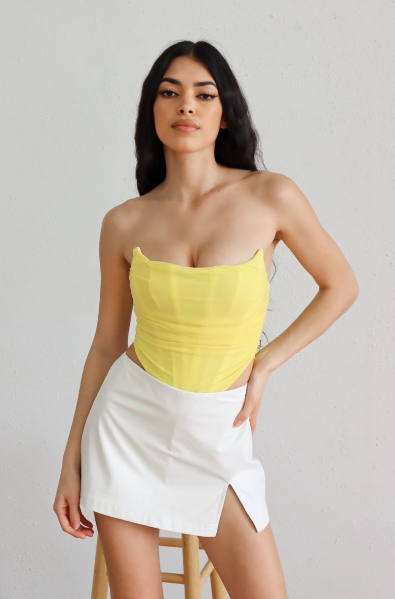 yellow strapless corset with white leather mini skort