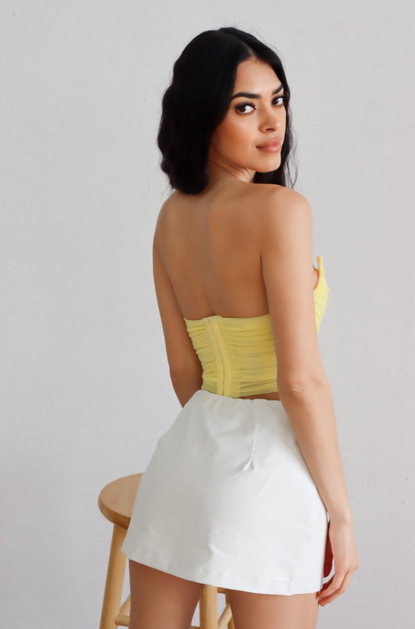 yellow strapless corset with white leather mini skort