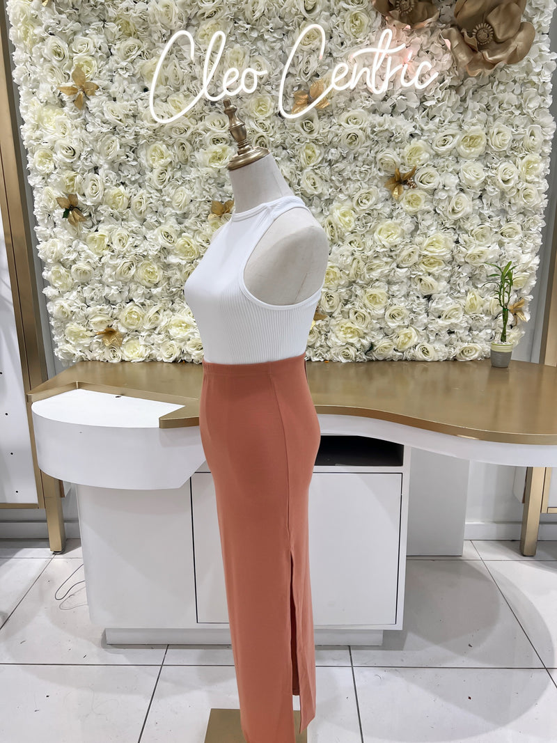 Knit ribbed maxi skirt with a side slit in peach.
