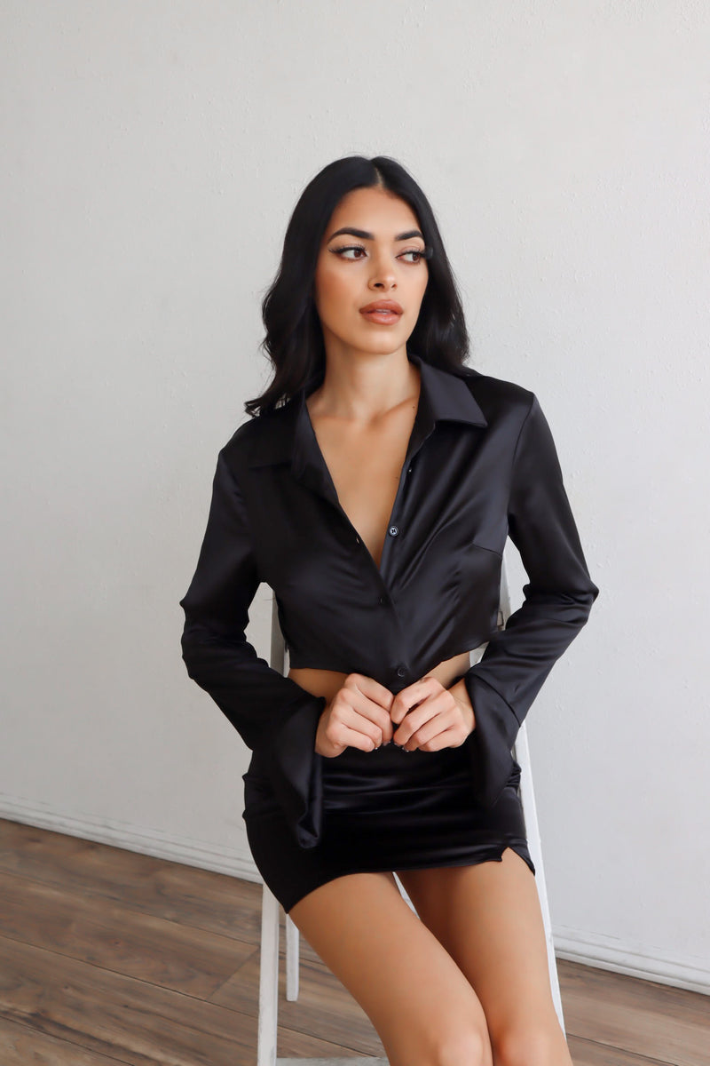 Cropped satin button-up with split sleeves in Black. Paired with a matching skirt.