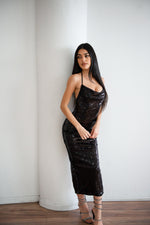 Black sequin dress with a halter neck, low back, and slit in the back.